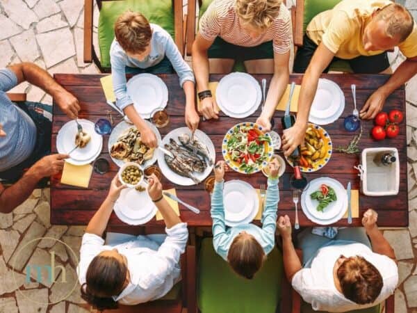 A group of people enjoying a nutrient dense meal around a table.