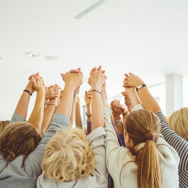 A group of people raising their hands in the air.